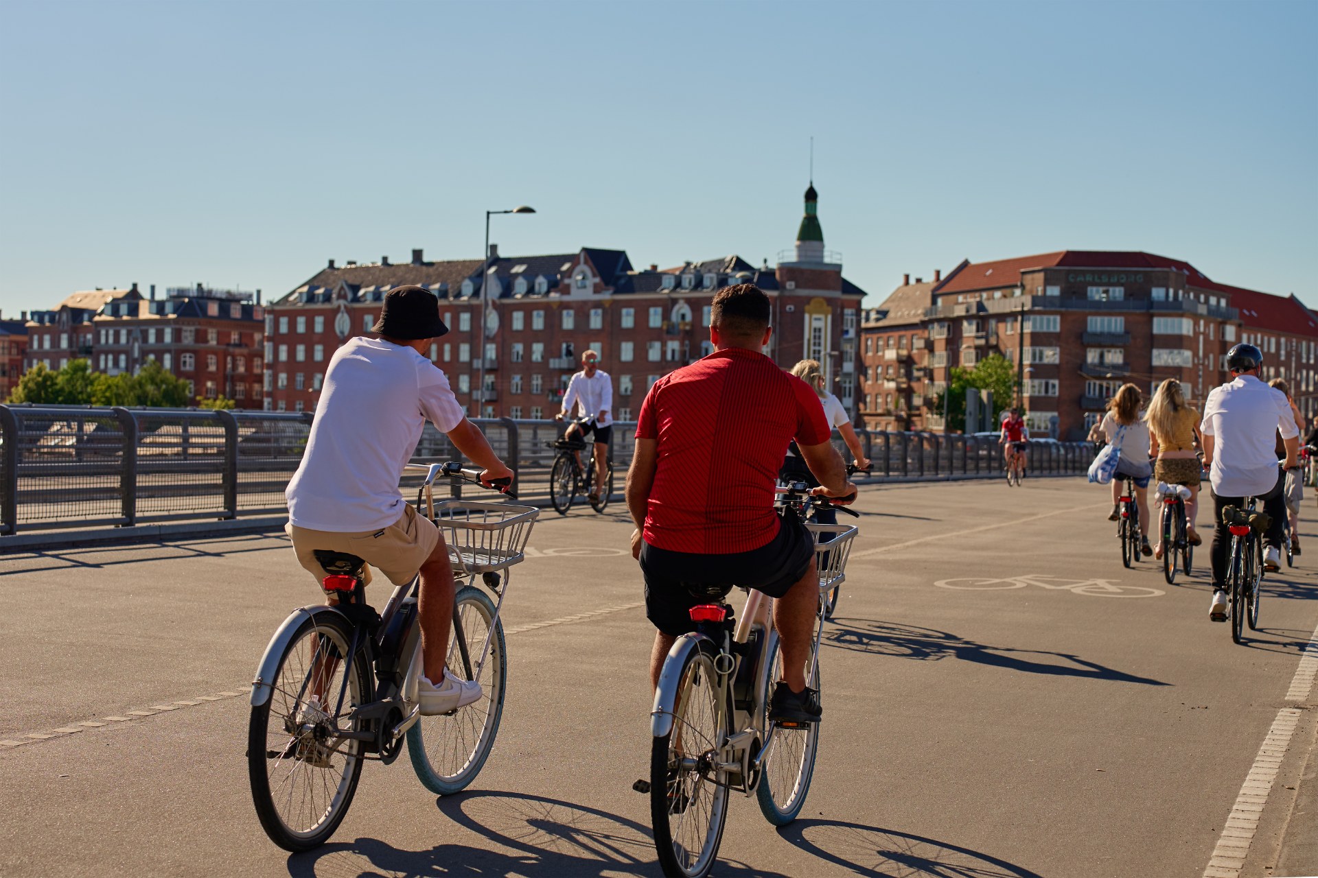 Young people riding bikes along a street in Copenhagen